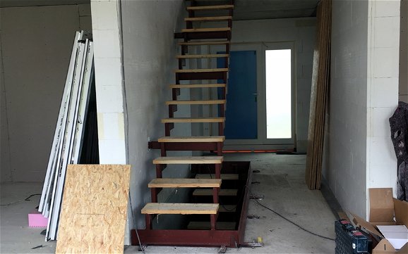Eingangsbereich mit Treppen mit provisorischen Stufen auf Holz.
