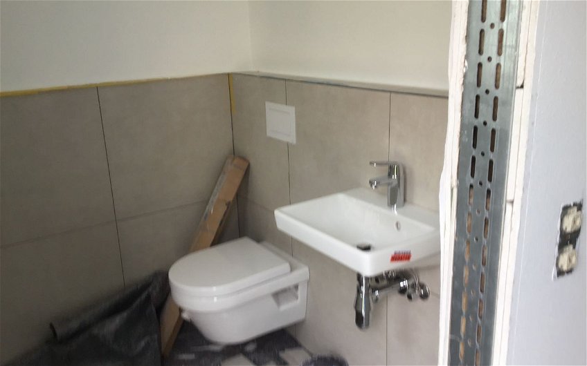 Sanitärendmontage im Gäste-WC der individuell geplanten Doppelhaushälfte Twin XXL von Kern-Haus in Korb
