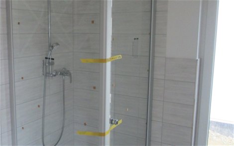 Die Dusche wurde mit einer Eckverglasung und formschöner Armatur versehen.