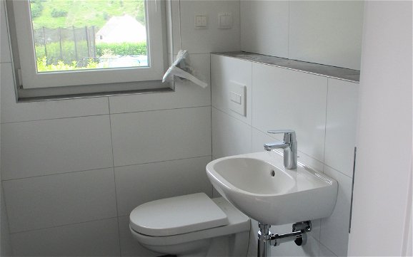 Im modernen Gäste WC wurden Toilette und Waschbecken montiert.