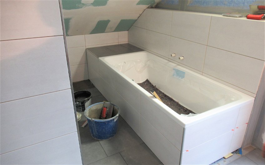 Die Schürze der Badewanne und die Wände im Bad wurden mit Fliesen versehen.