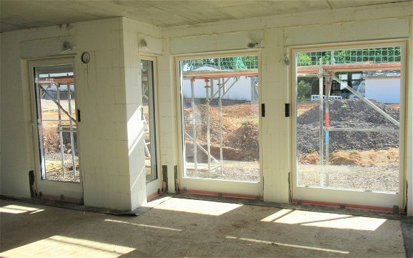 Bodentiefe Fenster wurden montiert und erhellen das Kern-Haus mit Tageslicht.