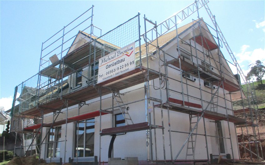 Für Zimmermann- und Dachdeckerarbeiten wurde das Außengerüst mit zusätzlichen Sicherheitsmaßnahmen erweitert.