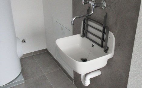 Im Hauswirtschaftsraum wurde eine Waschbecken mit Spritzschutz für Schmutzwasser montiert.