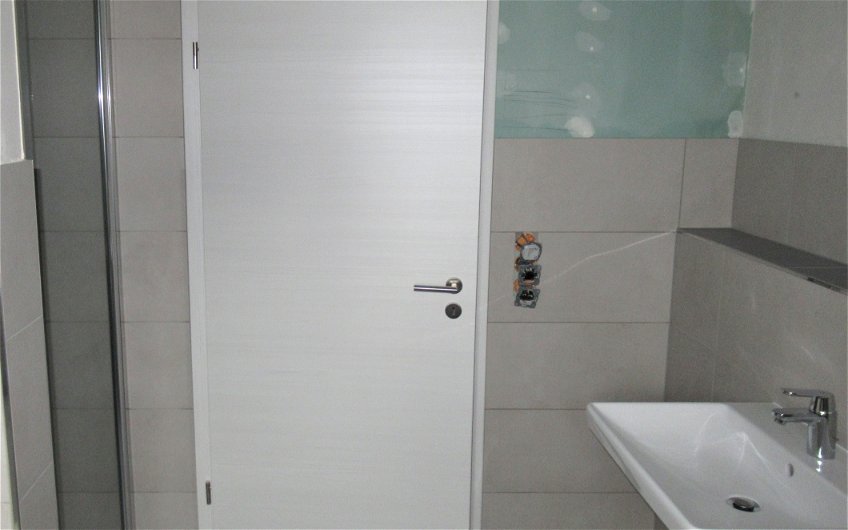Die Duschglastür und Sanitärobjekte wurden im Bad montiert.