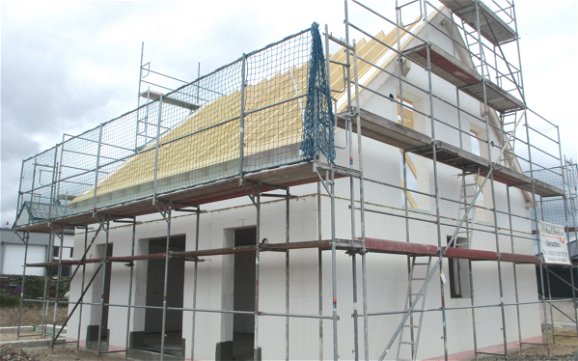 Für Zimmermann- und Dachdeckerarbeiten wurde das Außengerüst mit zusätzlichen Sicherheitsmaßnahmen erweitert. 
