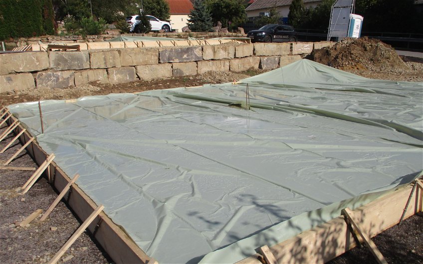 Nachdem die Bodenplatte betoniert wurde, muss der Beton aushärten.