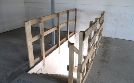 Während der Bauphase bietet ein Holzgeländer am Treppenaufgang Sicherheit.