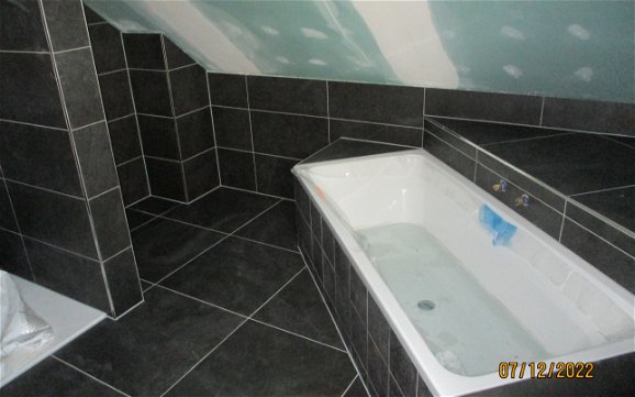 Highlight des Bades ist die Badewanne mit praktischer Ablagefläche.