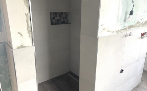 Der Duschbereich wurde gefliest und eine Ablagefläche für Duschutensilien geschaffen.