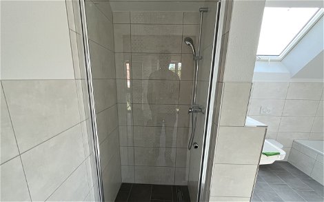 Die Glastür im Duschbereich schützt vor Spritzwasser.