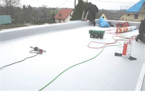 Die Dachdecker beenden die Arbeiten auf dem Flachdach.